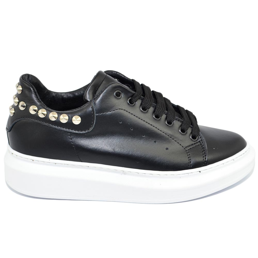 Sneakers uomo bassa in vera pelle vitello nera tinta unita con borchie argento fondo tondo bianco moda street